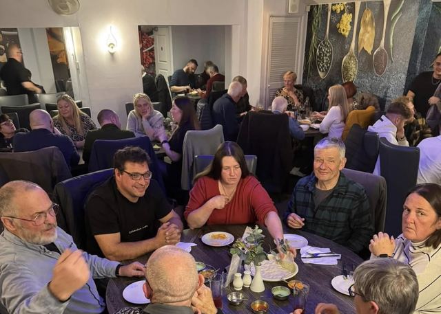Guests sharing dinner around a table in a busy Millers dining room